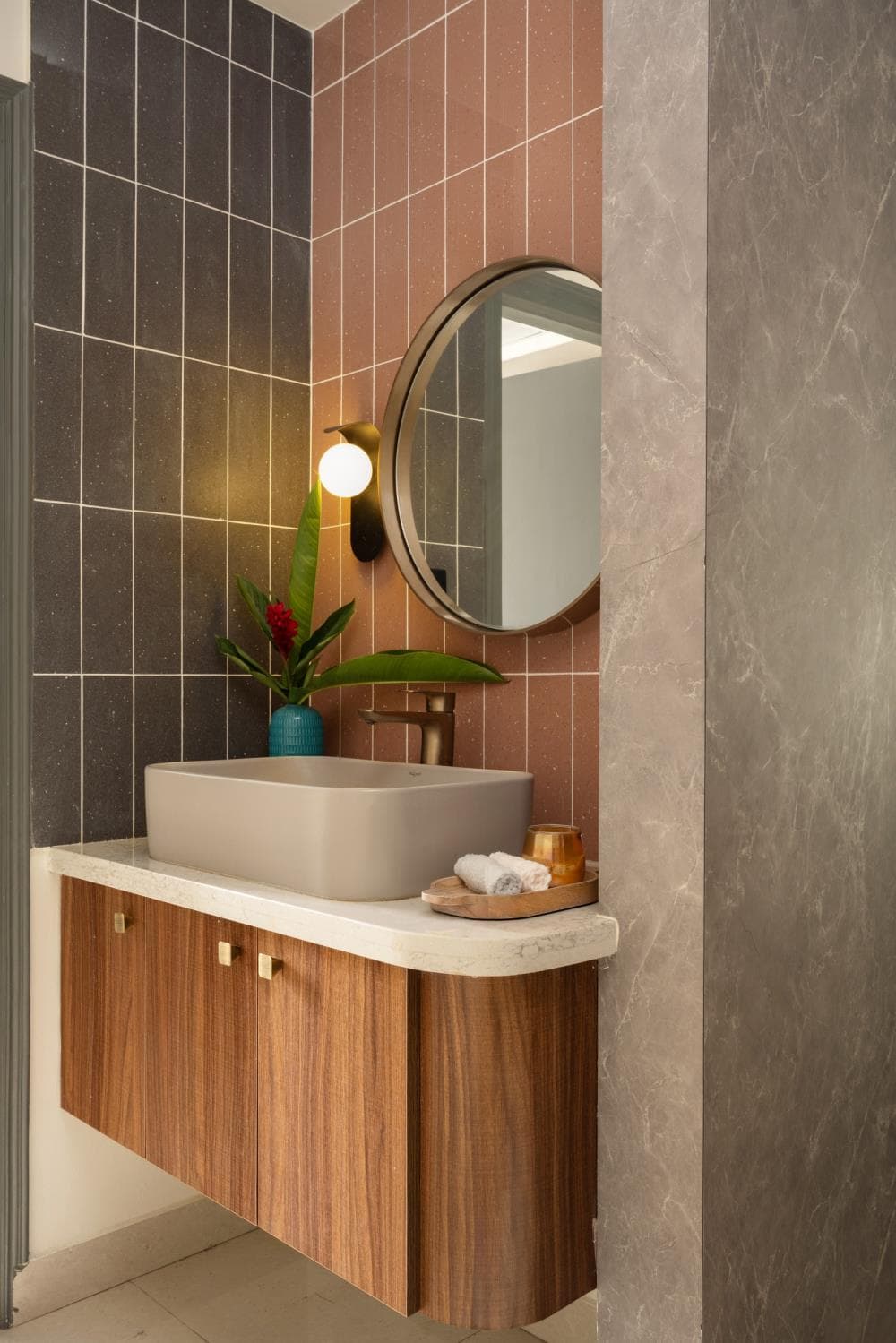 Common washroom vanity with a wood-toned counter and a round backlit mirror