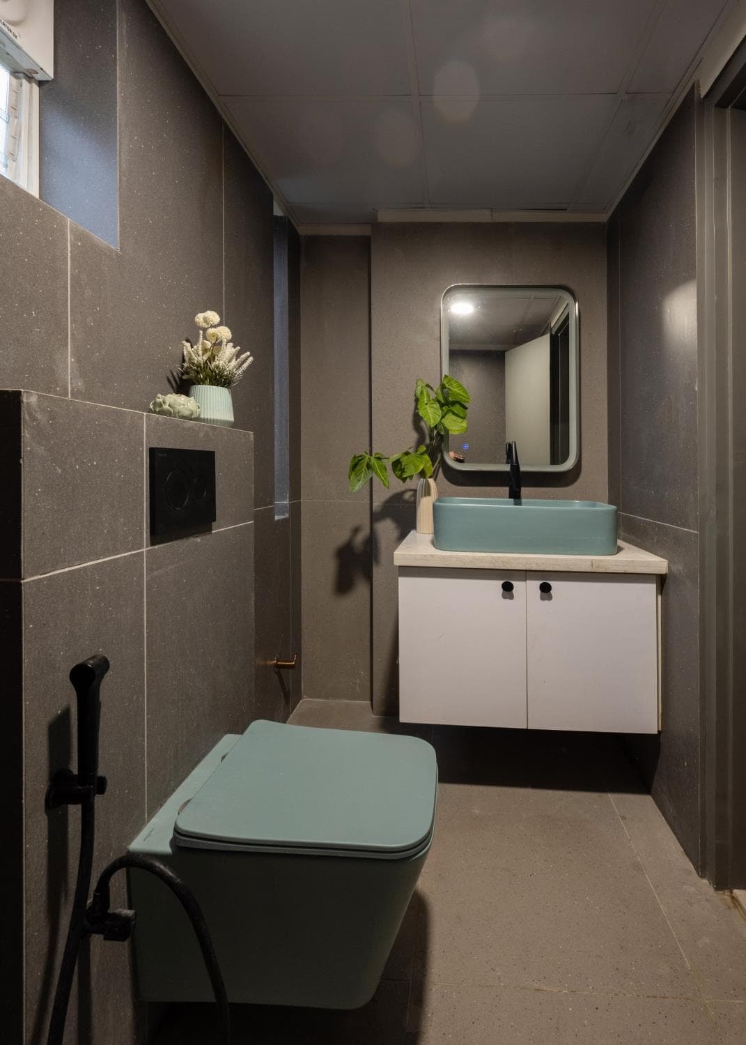 Kids' washroom shower area with patterned tile and glass partition