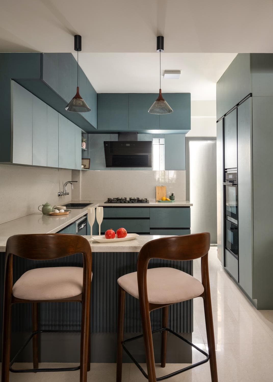 Kitchen island in blue-grey laminate with a marble-effect countertop and pendant lighting