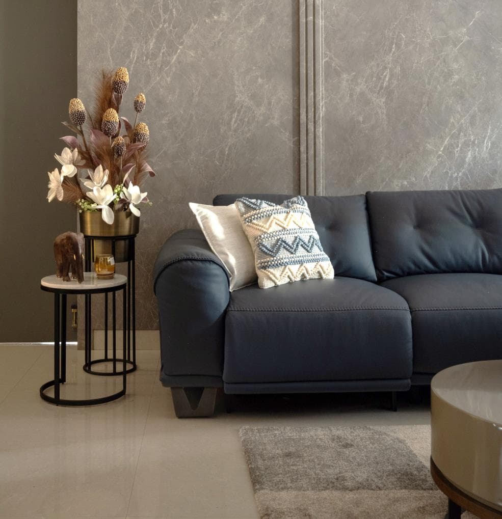 Detail of the living room seating with layered cushions and a low wooden side table
