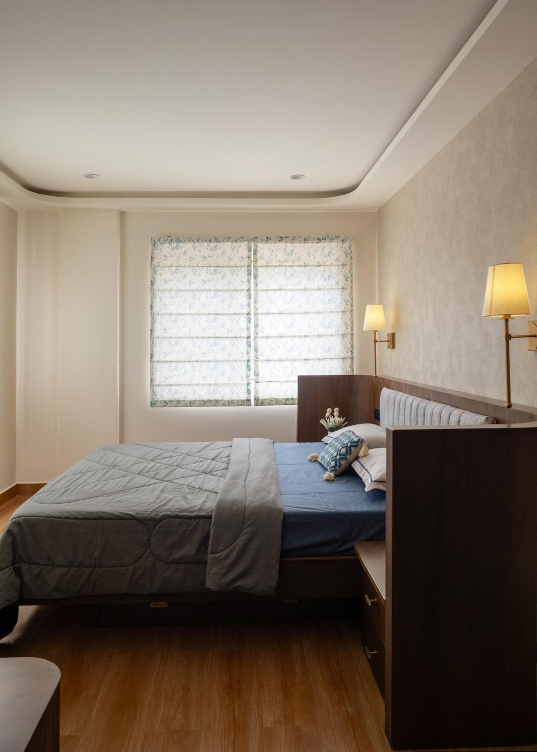 Master bedroom with a panelled headboard wall and layered neutral bedding