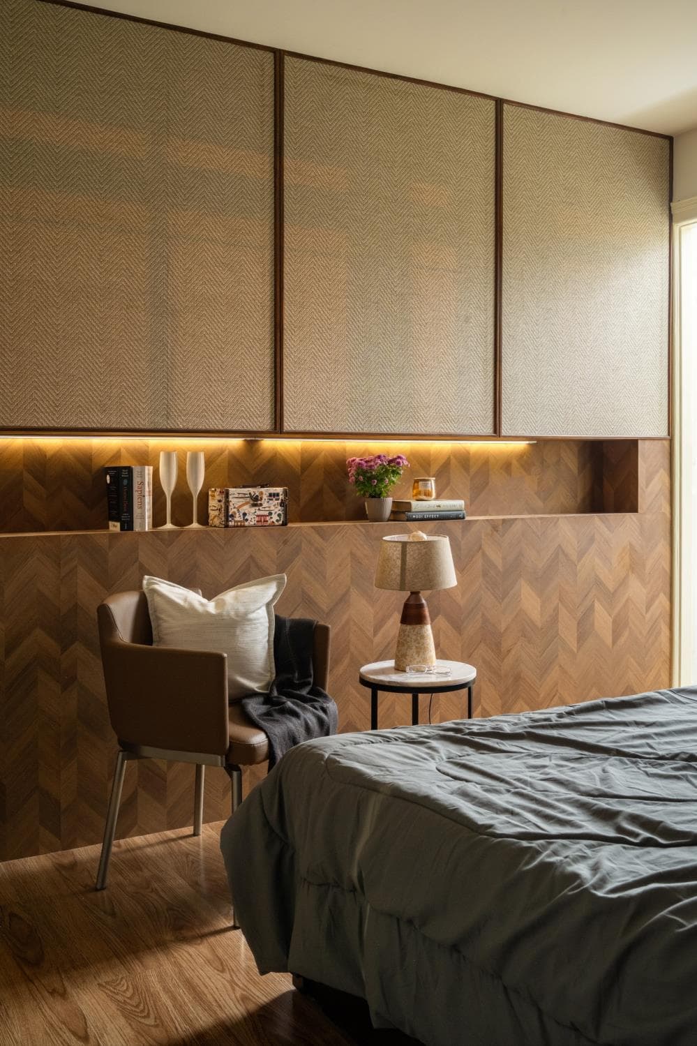 Parents' bedroom with an upholstered headboard and warm bedside lighting